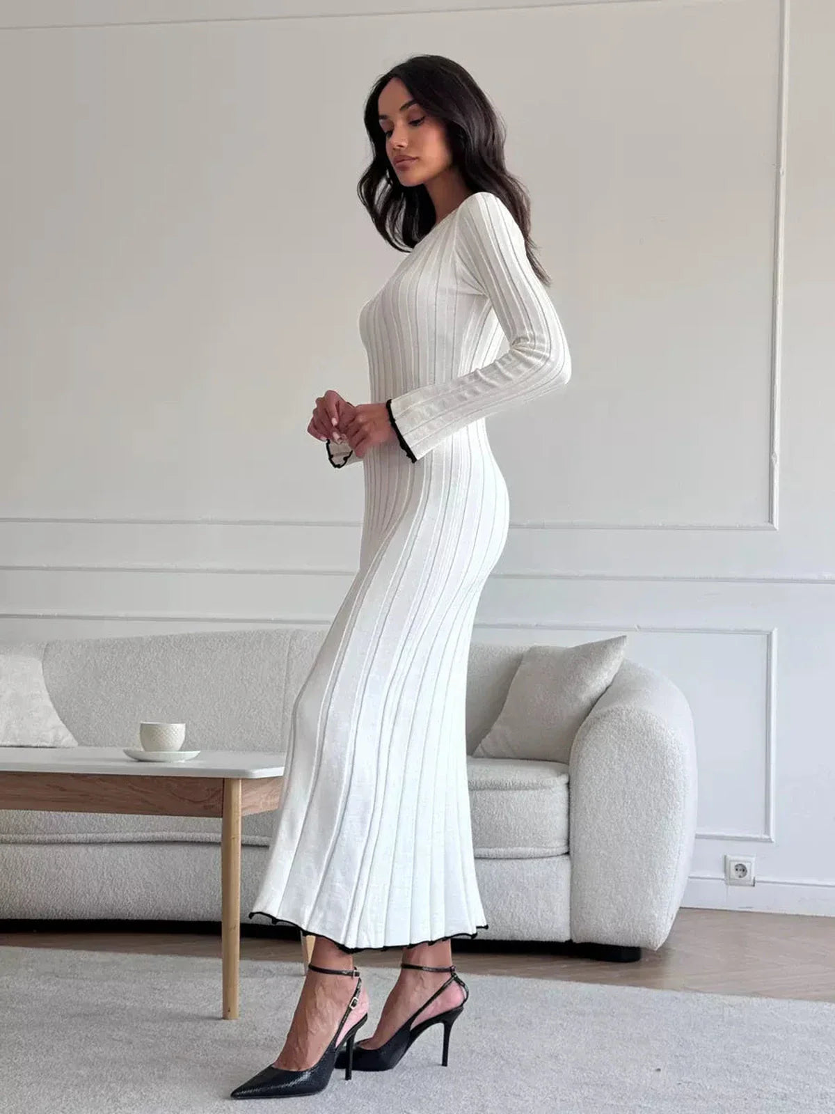 Ivory Grace Maxi Dress in ribbed knit, showcasing elegant silhouette and ruffle trim, styled with chic heels.