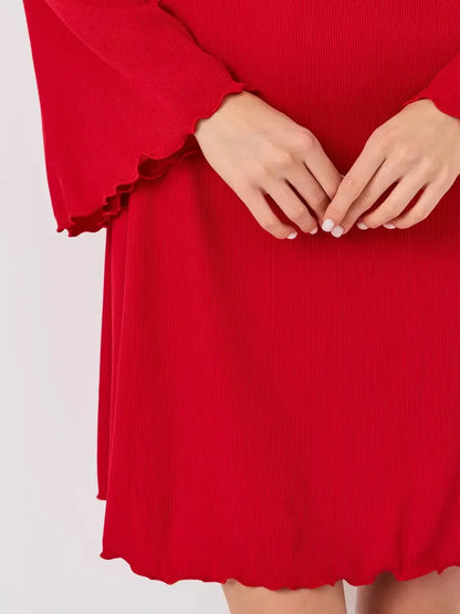 Close-up of hands on a red flare cutout mini dress showcasing its textured fabric and playful ruffled hem.