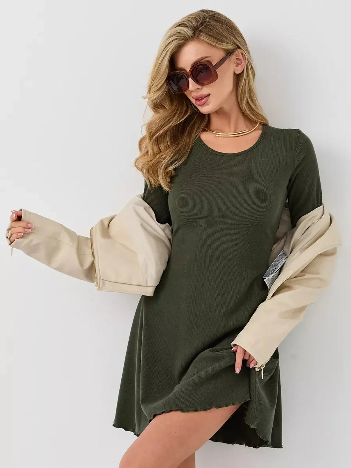 Woman wearing an Ivy Bell mini dress with flared sleeves and sunglasses, styled with a jacket.