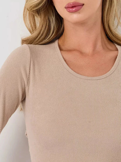 Close-up of a warm beige ribbed mini dress featuring a U-neckline and long sleeves, showcasing its luxe fabric.