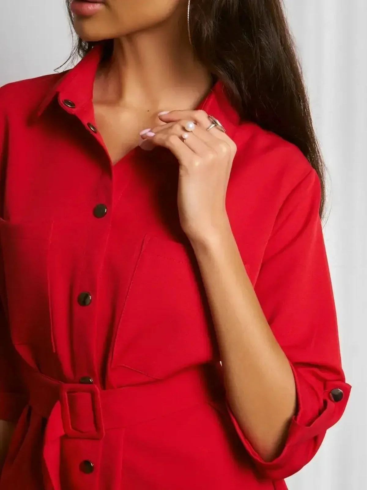 Close-up of a woman wearing a red belted mini dress highlighting its sculpted fit and classic shirt-dress style.