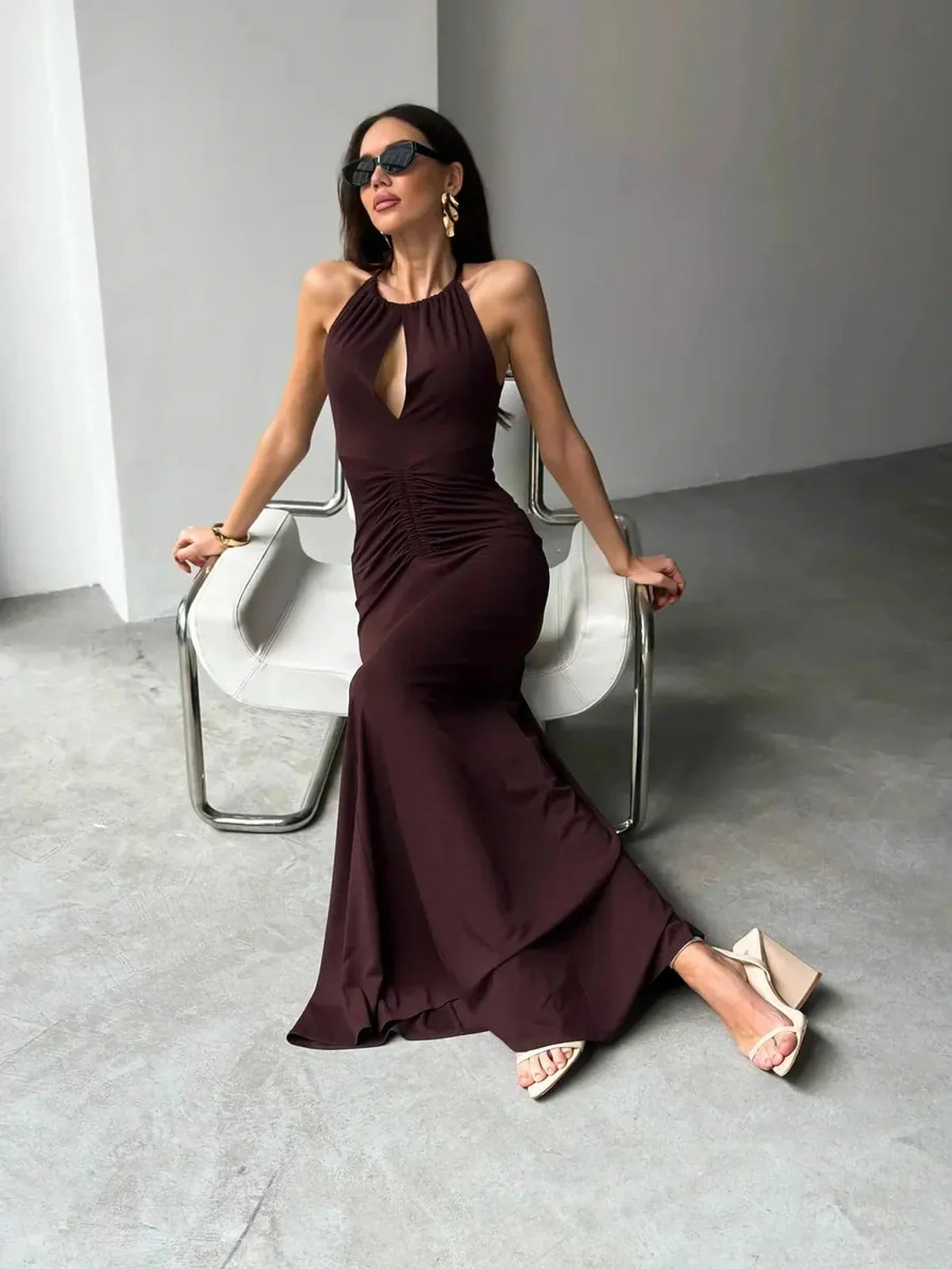 Model wearing the elegant Maxi Dress Sienna in rich sienna hue with halter neckline and sleek design.