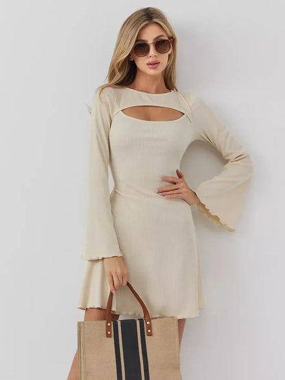 Model showcasing the Sculpted Grace mini dress with a boat neckline and front cutout, styled with a tote bag.