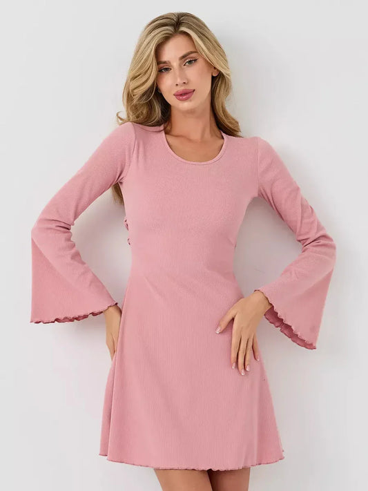 Model wearing a soft pink Blush Flare mini dress with bell sleeves and a scoop neckline.