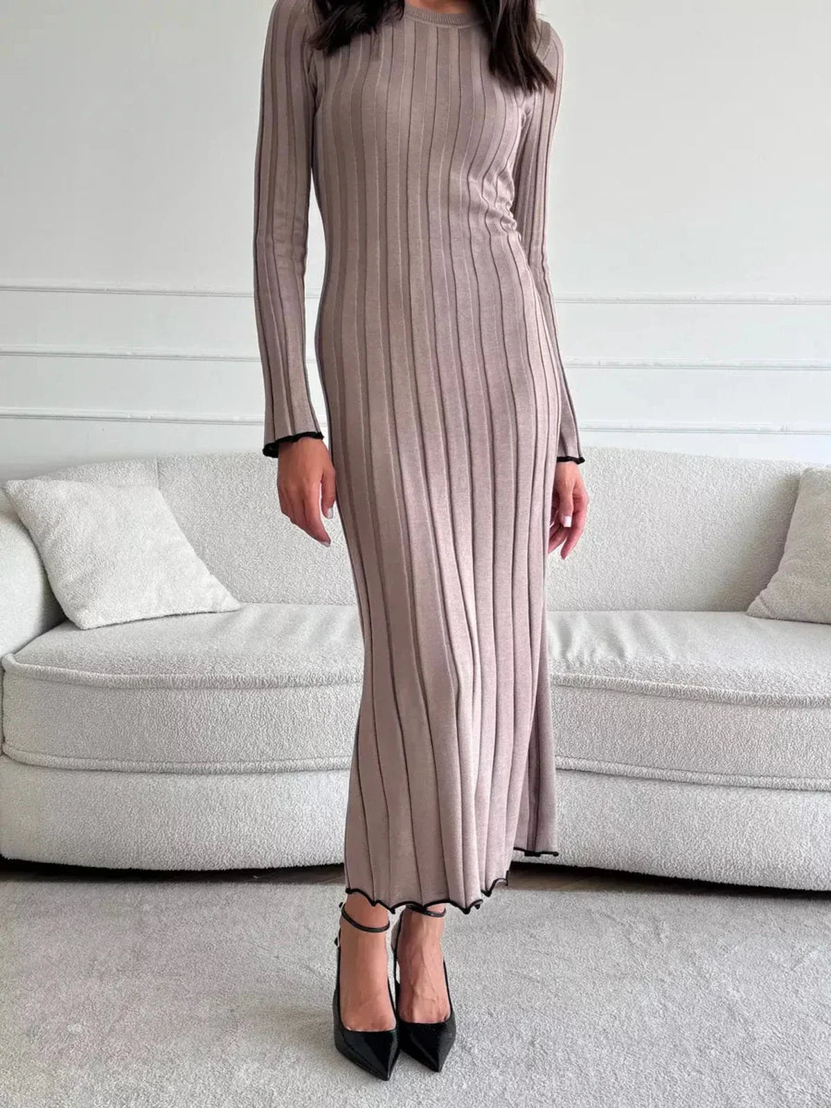 Elegant ribbed knit Contour Maxi Dress with long sleeves and ruffled hem, highlighting a sleek silhouette.