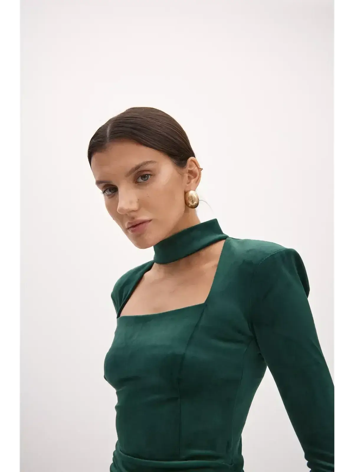 Model showcasing a bodycon emerald green midi dress with a choker neckline and stylish square cutout.