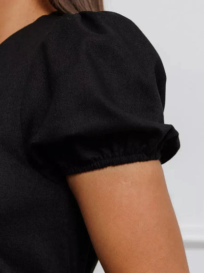 Close-up of puff sleeve detail on the Maxi Dress Noir Belle, showcasing elegant black fabric and stylish design.