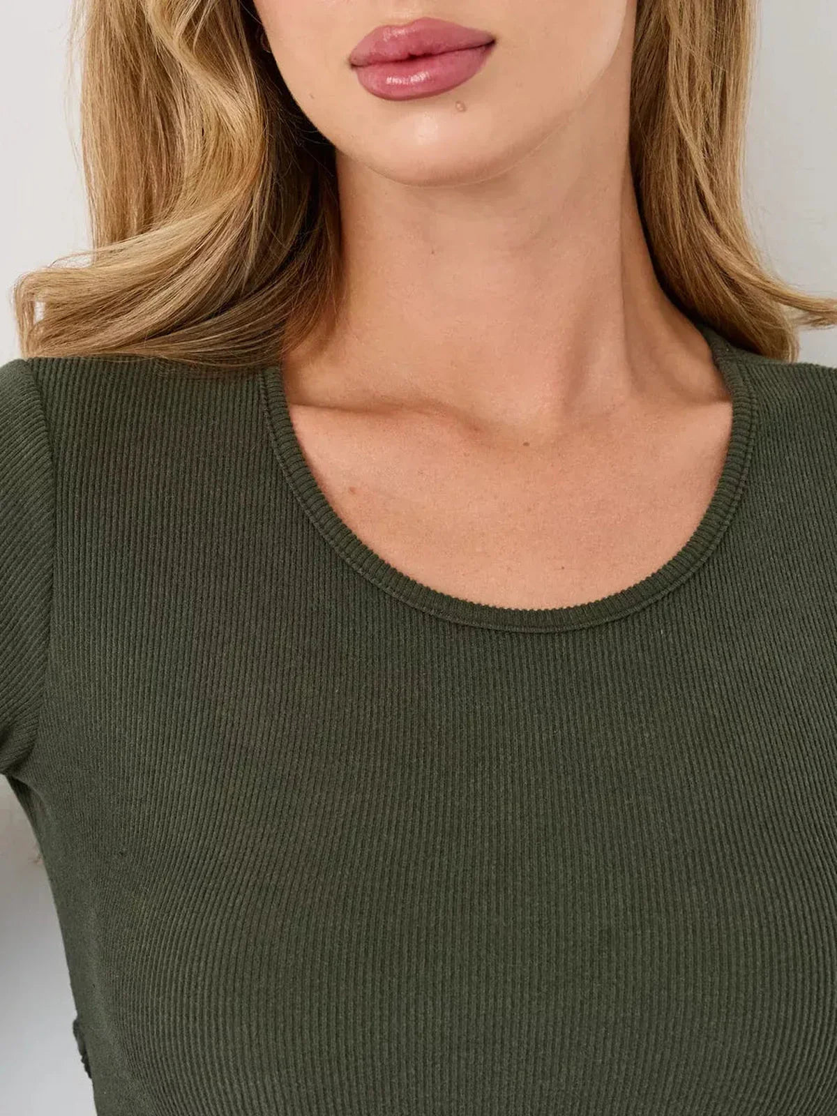 Close-up of a U-shaped neckline on a ribbed olive green mini dress featuring soft, structured fabric.