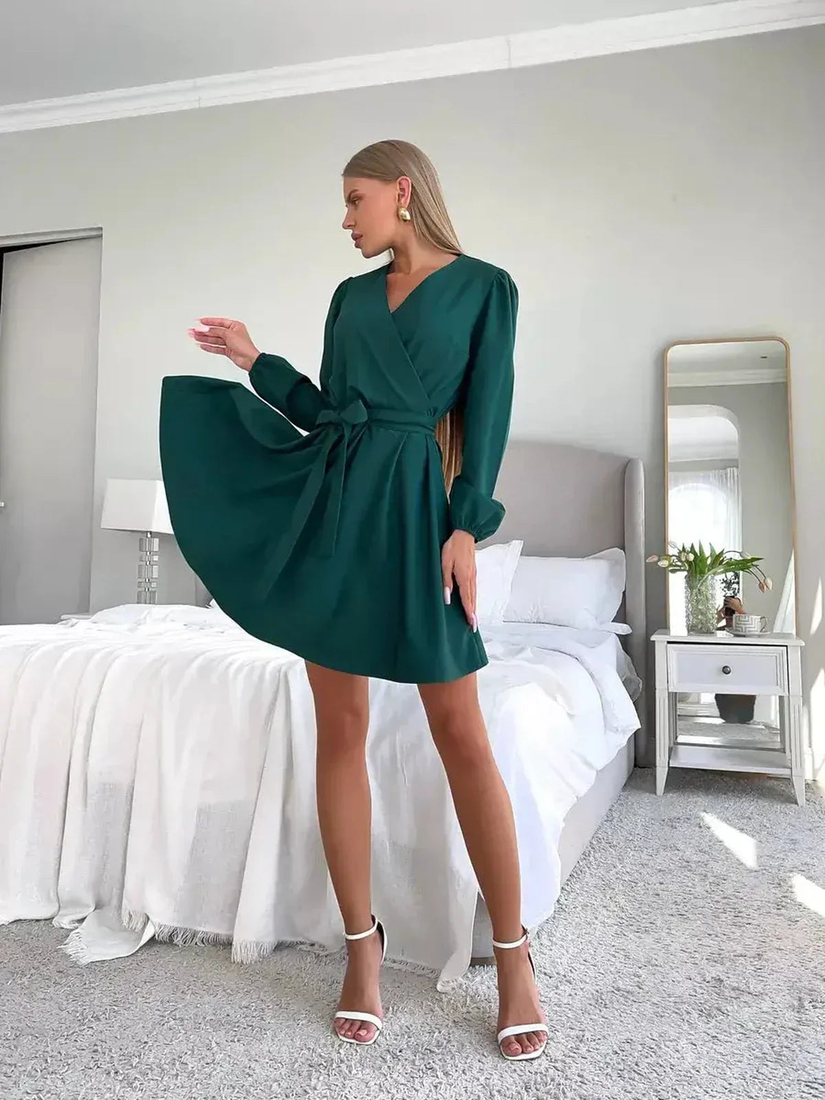Stylish model showcasing the Emerald Charm mini dress, a wrap-style dress in rich green, perfect for modern femininity.
