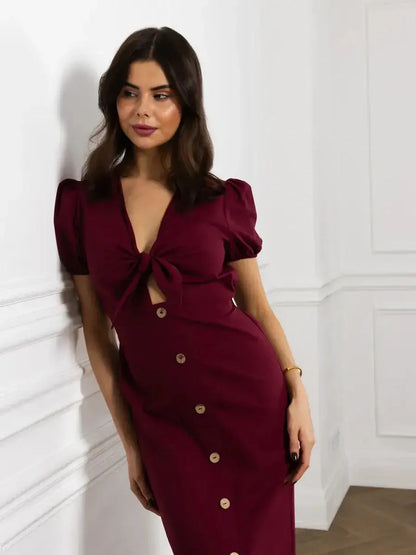 Model in burgundy maxi dress with front bow and buttons, showcasing sophisticated style and elegant fit.