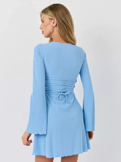 Back view of a pastel blue Sky Belle ribbed knit mini dress with long fluted sleeves and a flared hem.