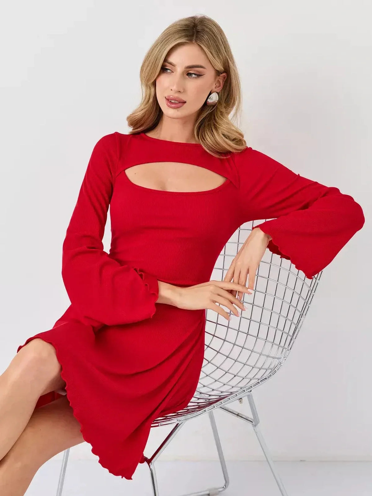 Model wearing a red flare cutout mini dress with bell sleeves, showcasing modern style and daring design.