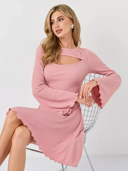 Model showcasing the Blush Whisper pink long sleeve dress with flared sleeves and sculpting fit, perfect for summer.