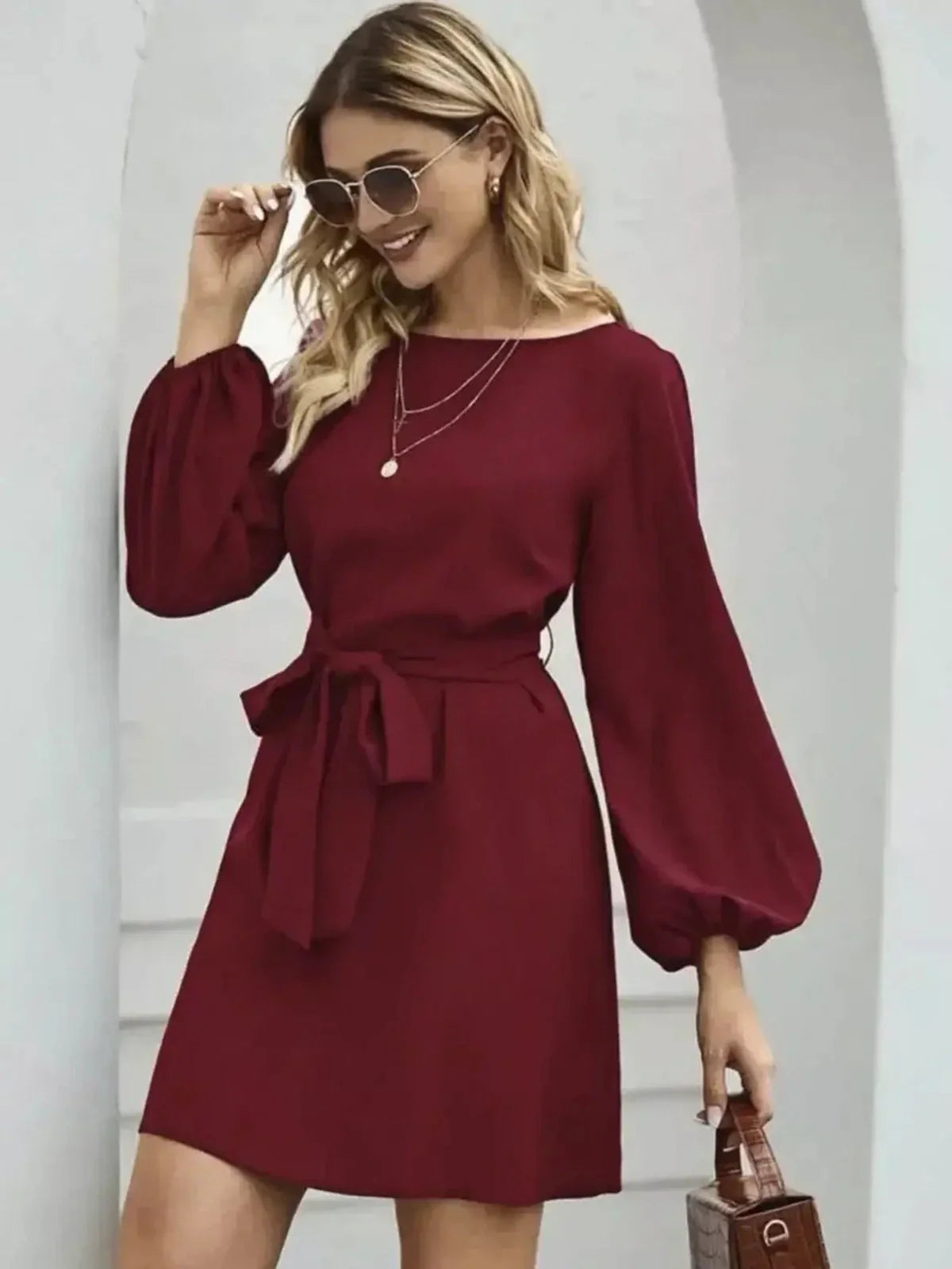 Elegant burgundy mini dress with voluminous long sleeves and a cinched waist, perfect for summer or wedding guest attire.