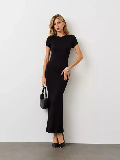 Model wearing a sleek Noir Curve Maxi Dress in black, showcasing its sculpted silhouette and minimalist design.