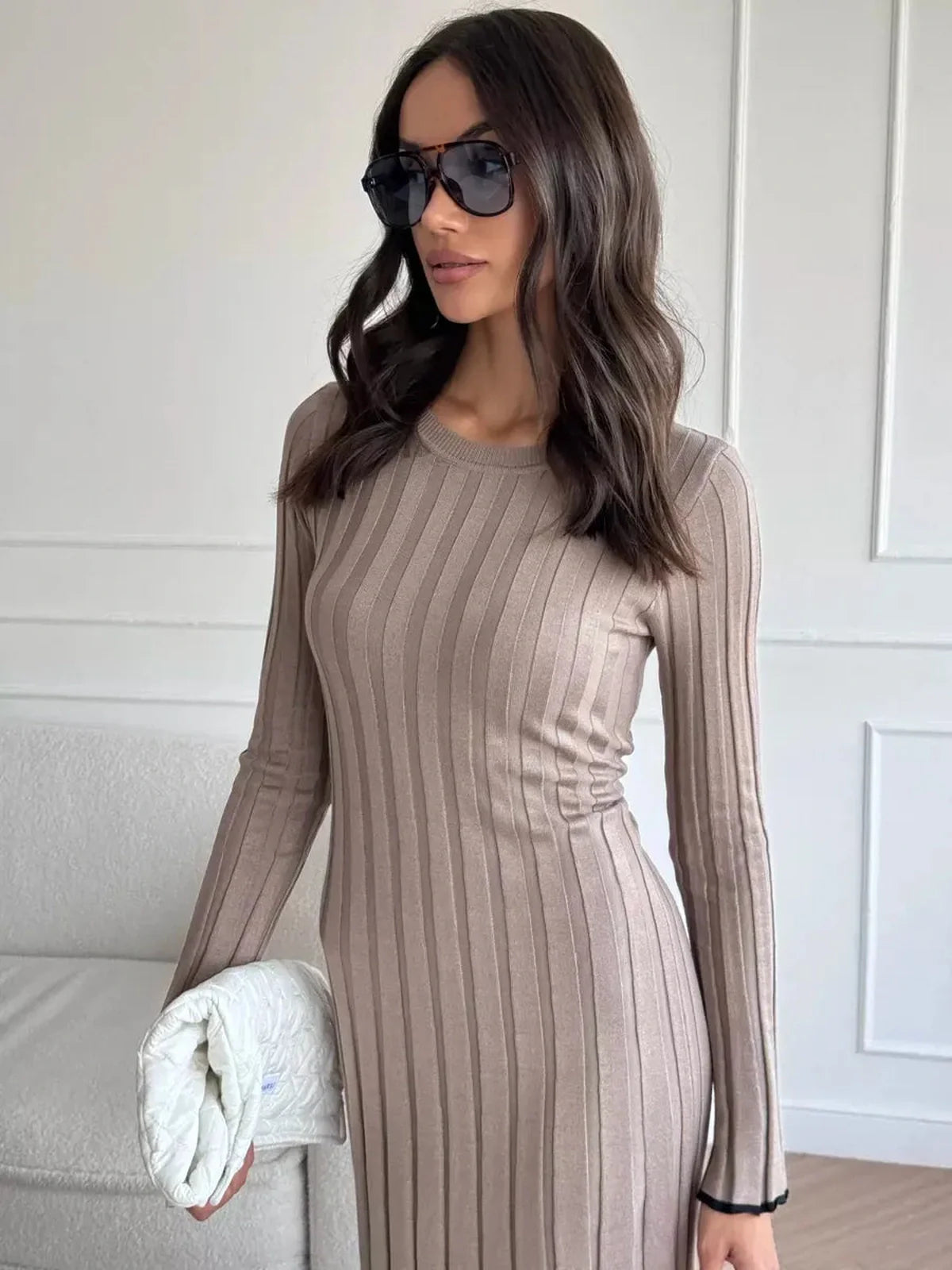 Woman wearing a ribbed knit Contour Maxi Dress in neutral tones, styled with sunglasses and a chic handbag.