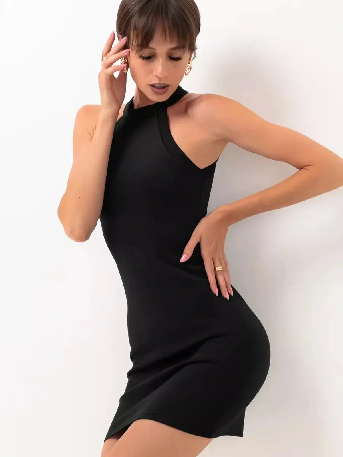 Model showcasing a sleek black midi dress with halter neckline and tailored fit for evening occasions.