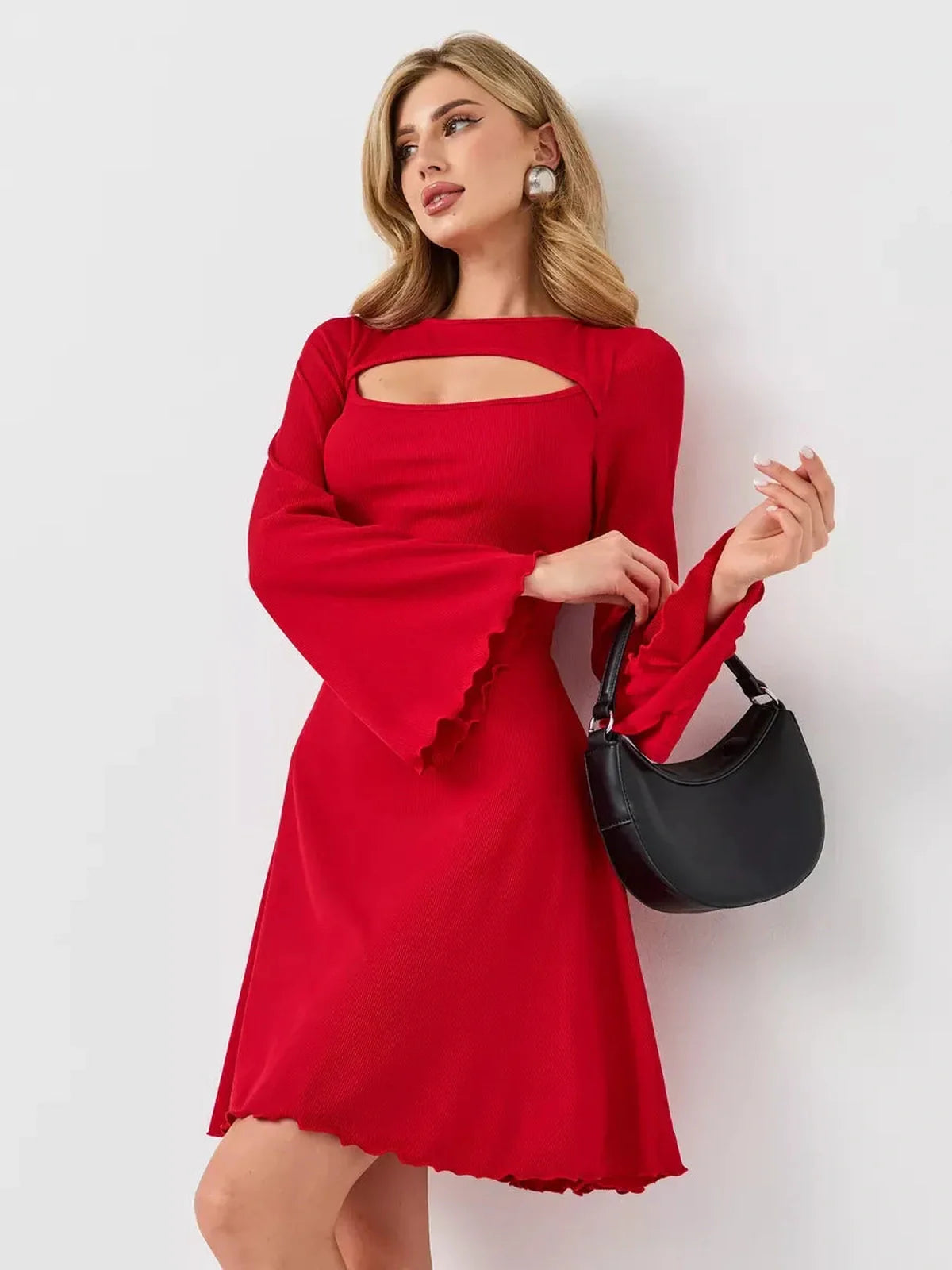 Model in a red flare cutout mini dress with bell sleeves, holding a black handbag, showcasing modern elegance.