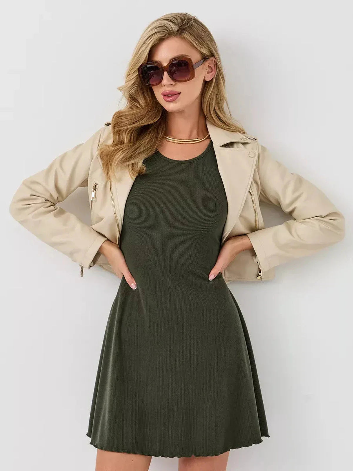 Model wearing Ivy Bell mini dress with flared sleeves, paired with a chic jacket and sunglasses, showcasing a stylish look.