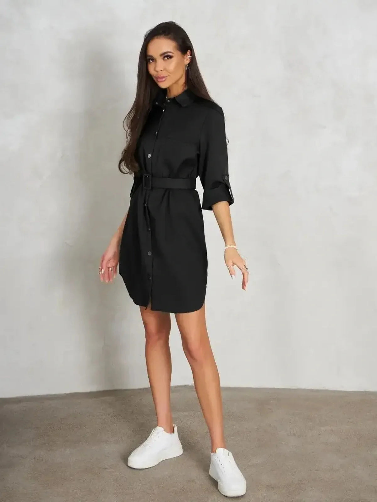 Model wearing the Urban Edit Mini black dress, showcasing a polished silhouette and detachable belt.