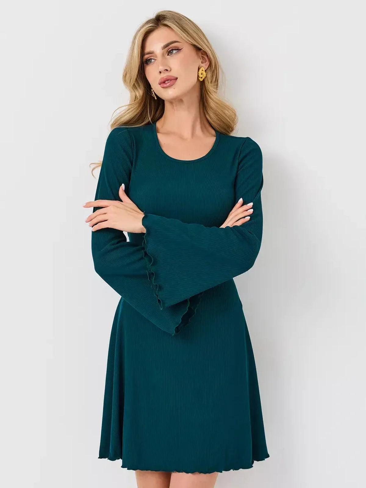 Emerald Whisper mini dress featuring a flared hem and bell sleeves, perfect for stylish occasions.