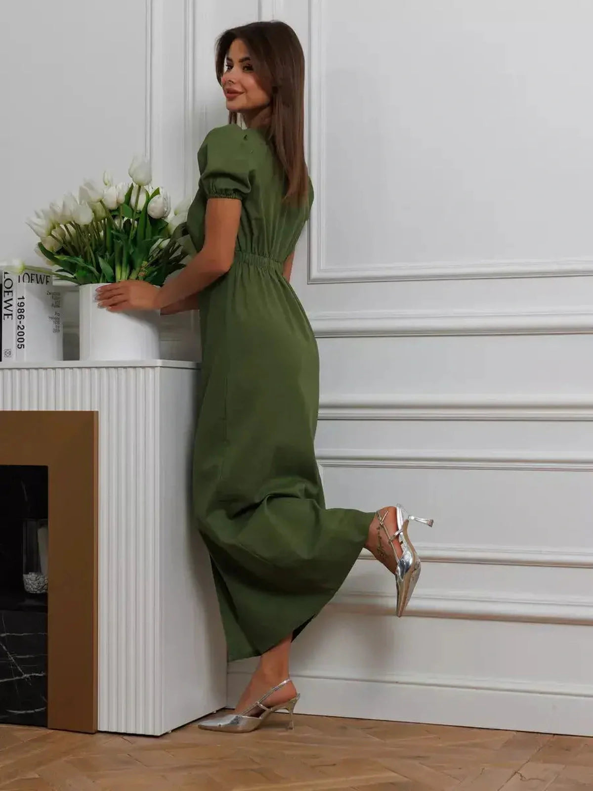 Model showcasing the Olive Whisper Maxi Dress in khaki, featuring puff sleeves and a bow-tie front.