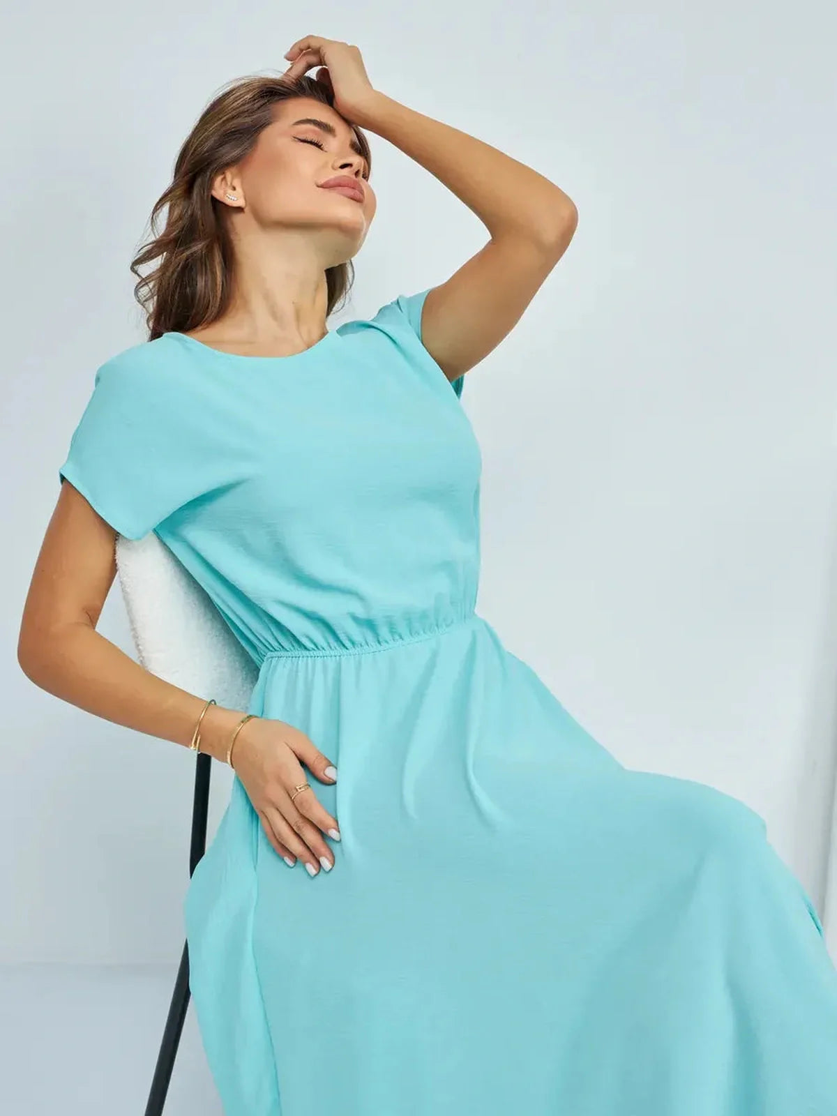 Model enjoying comfort in a light blue maxi dress with a flattering waistline and elegant design.