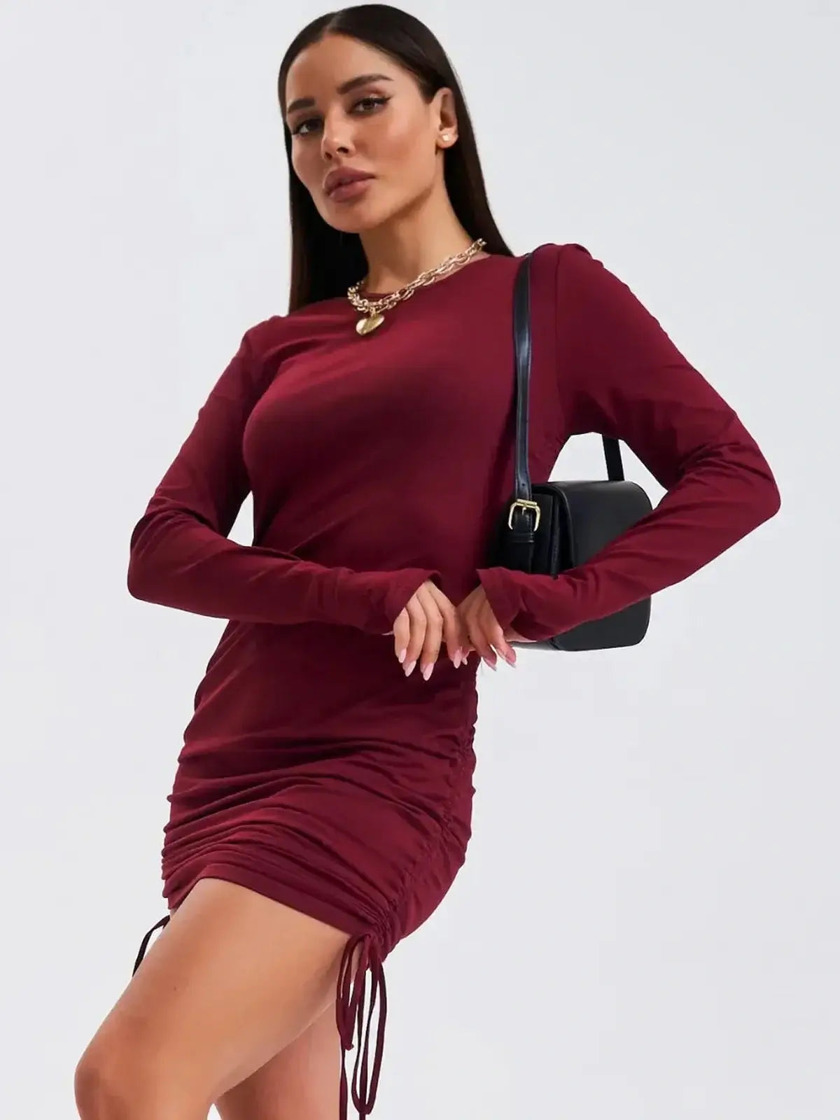 Burgundy Sculpt long sleeve mini dress with side draping, perfect for cocktail or wedding guest occasions.