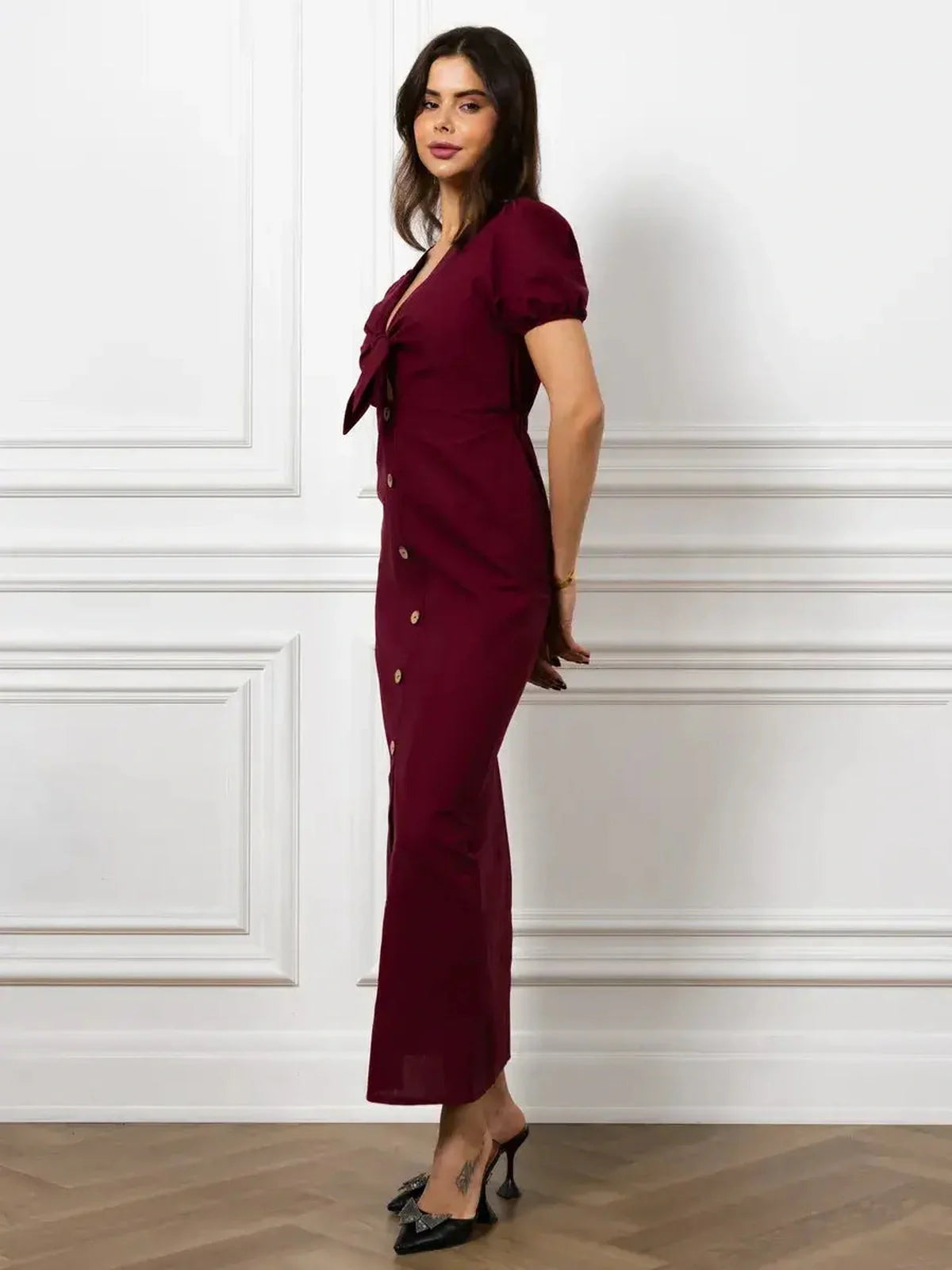 Maxi Dress Merlot Grace featuring a front bow, button detail, and elegant slim silhouette in rich burgundy hue.