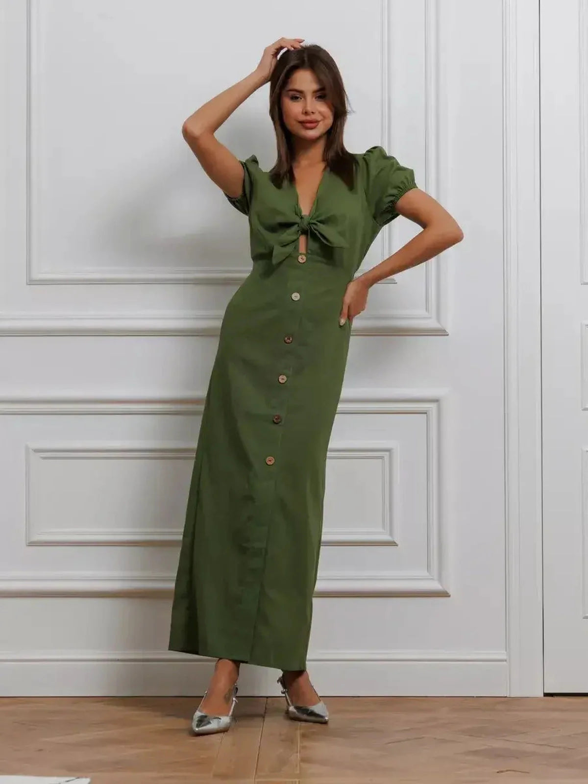 Model wearing an Olive Whisper Maxi Dress with puff sleeves and tie front, showcasing elegance in earthy tones.