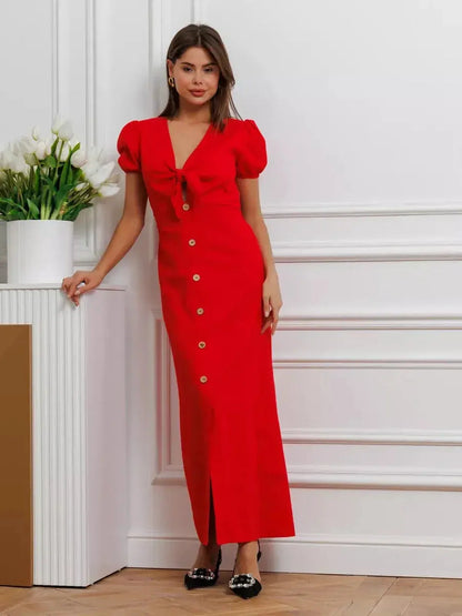 Maxi Dress Riviera Flame in red, featuring a tie-front bodice, puff sleeves, and a full-length button-down skirt.