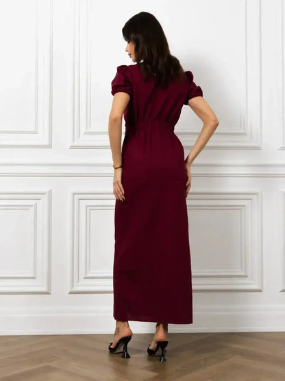 Back view of Maxi Dress Merlot Grace featuring a sleek silhouette, elasticated waist, and structured puff sleeves.