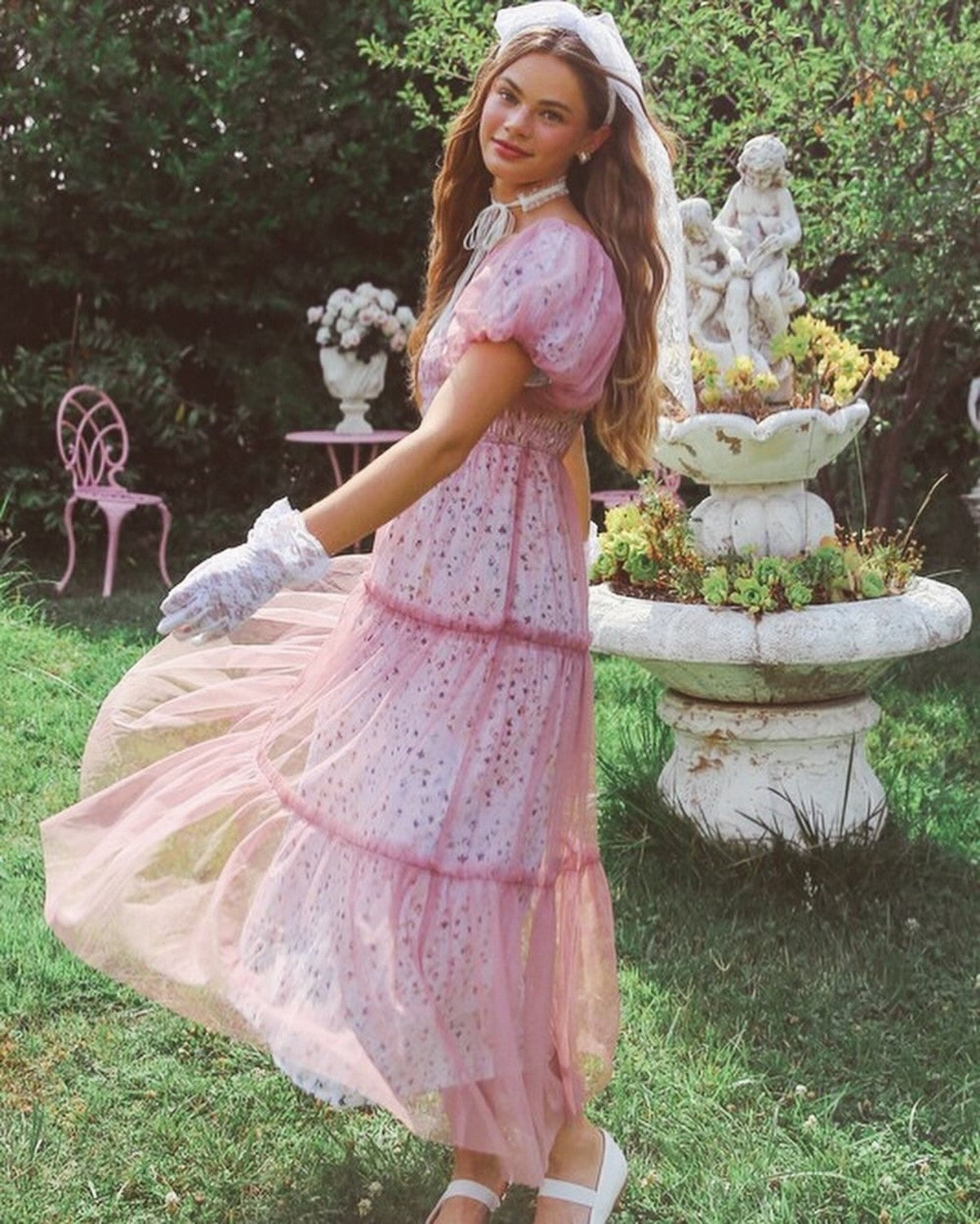Iris Women's Dress featuring a beautiful pink maxi dress in a garden setting, perfect for special occasions and summer wear.