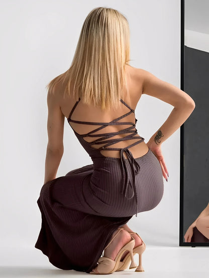Model showcasing the back of the Obsidian Midi Dress with strappy details and a sculpted fit.