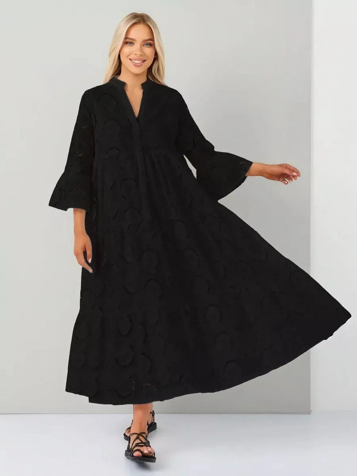 Elegant woman in a black broderie maxi dress showcasing a flowy silhouette and romantic style.
