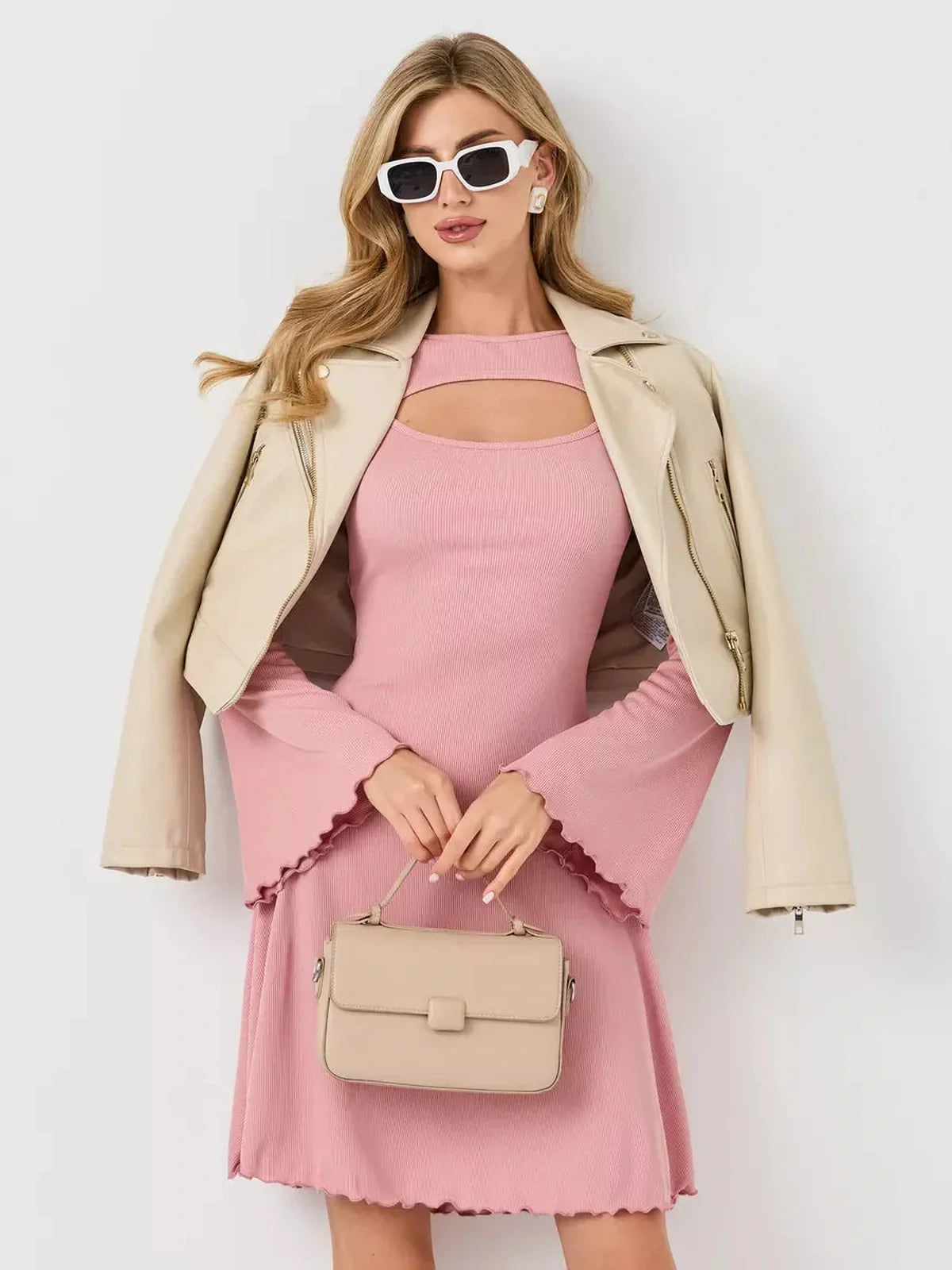 Stylish model showcasing the Blush Whisper pink dress paired with a chic jacket and handbag.