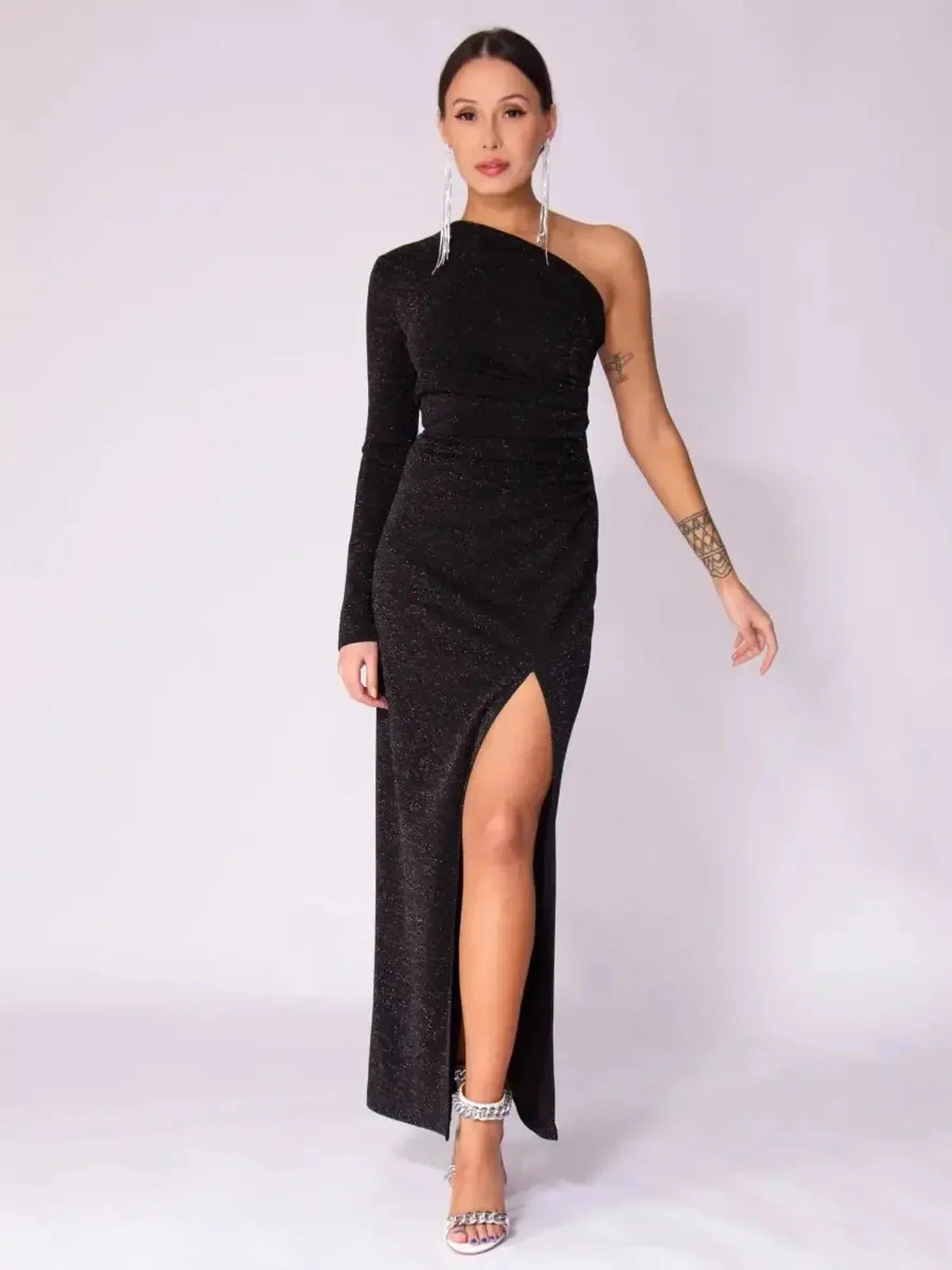 Model wearing Luna Noir Maxi Dress with one-shoulder design, dramatic leg slit, and shimmering fabric for evening elegance.