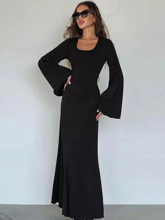 Elegant noir contour maxi dress featuring flared sleeves and a sculpting silhouette.