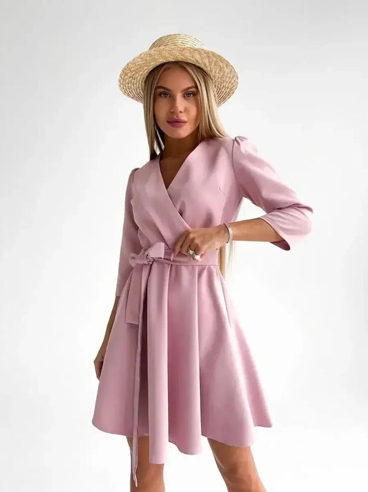 Stylish model wearing a pink mini dress with a V-neckline and removable belt, showcasing effortless elegance.