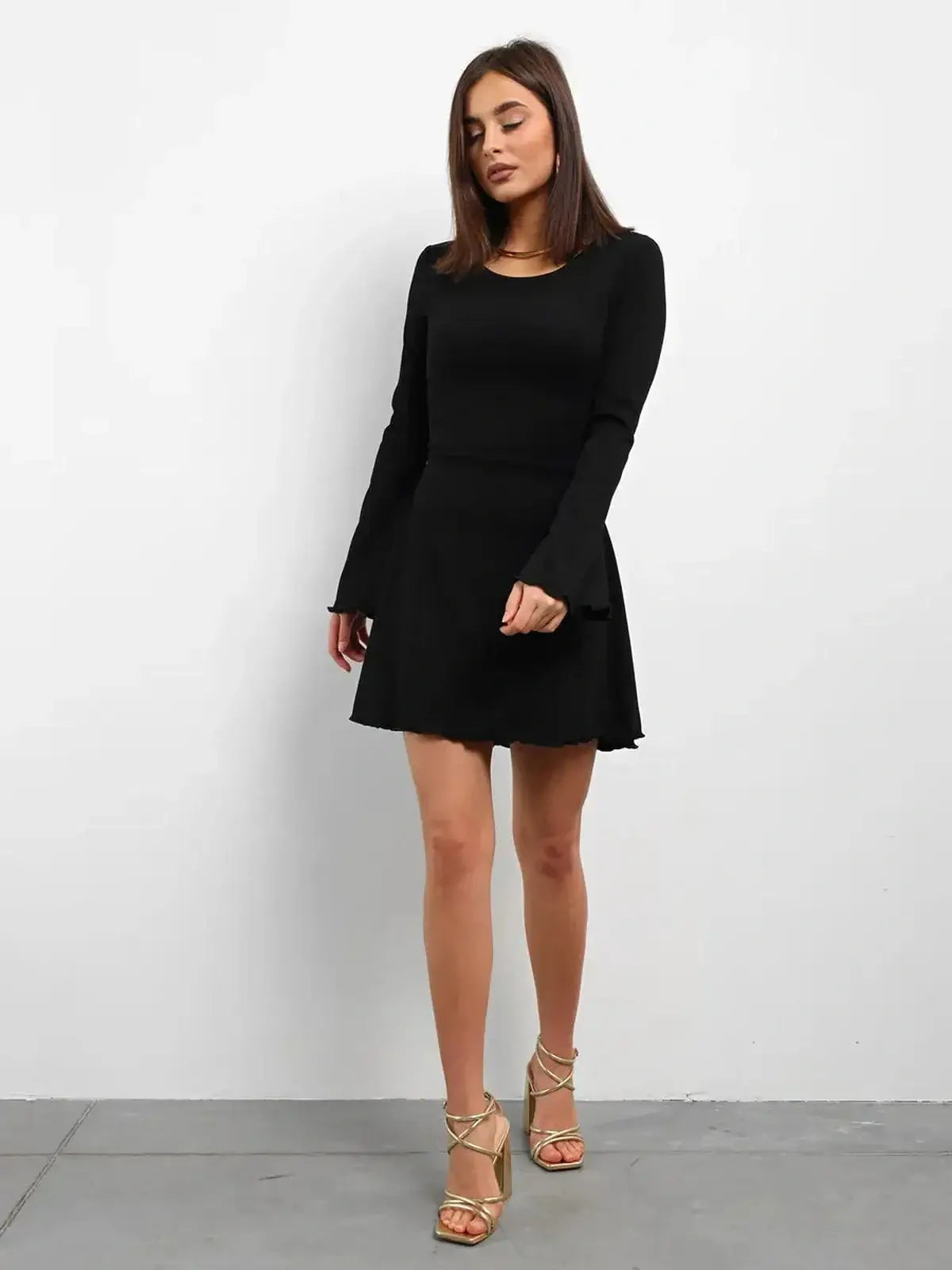 Black long sleeve mini dress with a flared skirt, perfect for casual or formal occasions.