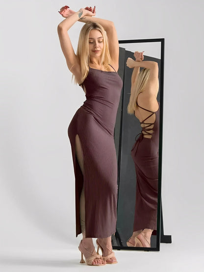 Stylish woman in Obsidian Midi Dress with strappy back and thigh-high slit, showcasing sculpted fit and elegance.