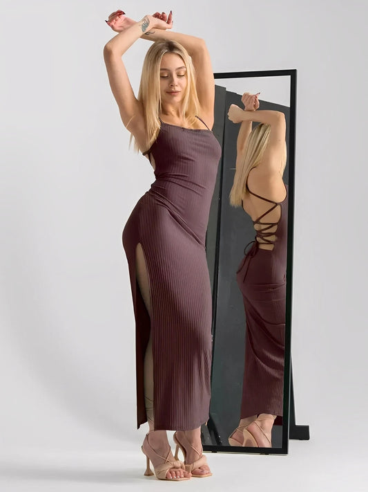 Stylish woman in Obsidian Midi Dress with strappy back and thigh-high slit, showcasing sculpted fit and elegance.