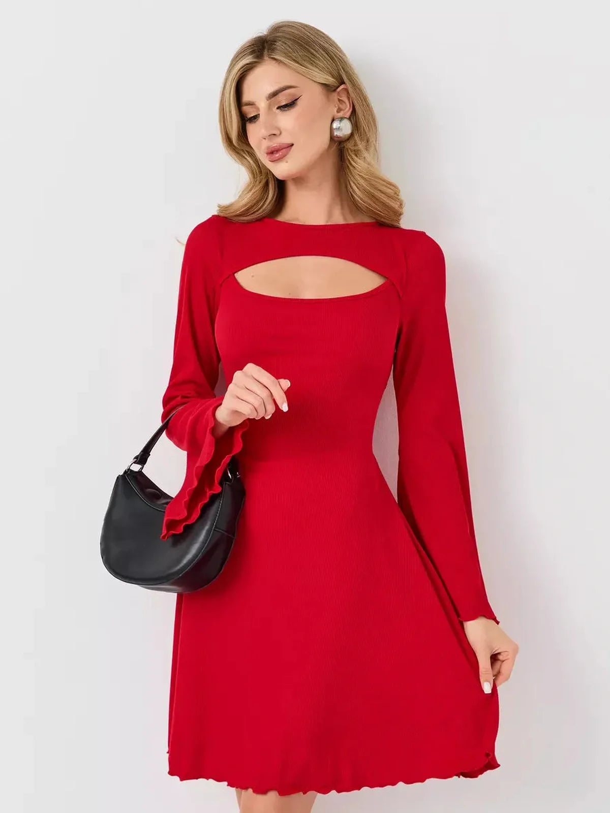 Sculpting red flare cutout mini dress with long sleeves and a defined A-line silhouette, paired with a black handbag.