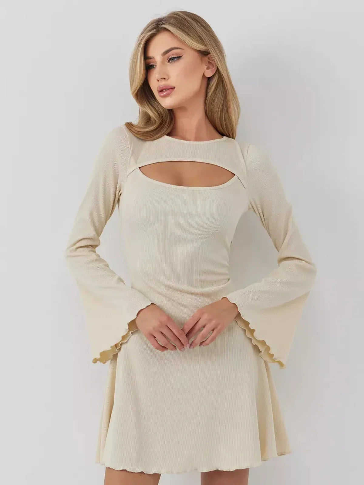 Model wearing the Sculpted Grace mini dress with long sleeves, boat neckline, and front cutout, showcasing elegant style.