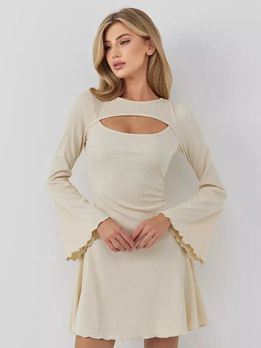 Model wearing the Sculpted Grace mini dress with long sleeves, boat neckline, and front cutout, showcasing elegant style.