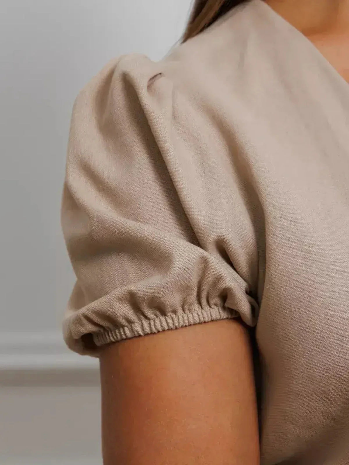 Close-up of puff sleeve detail on the Serene Bond Maxi Dress in soft neutral hue, showcasing refined elegance.