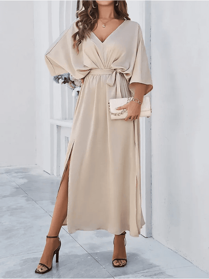 Flowing beige Serene Elegance Maxi Dress with deep V-neck, waist tie, and dramatic side slits for a chic summer look.