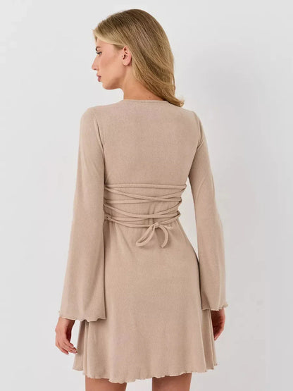 Back view of the Café Ribbon ribbed mini dress in warm beige, featuring a fitted silhouette and long bell sleeves.