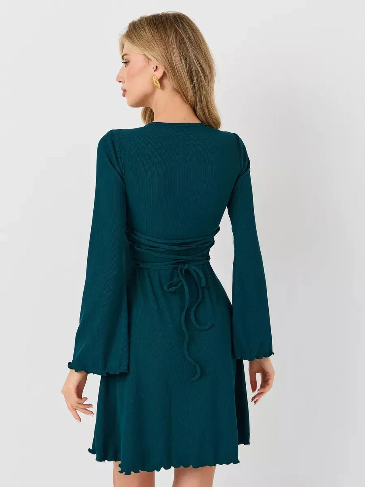 Back view of the Emerald Whisper mini dress, showcasing its A-line silhouette and elegant flared hem in rich emerald green.