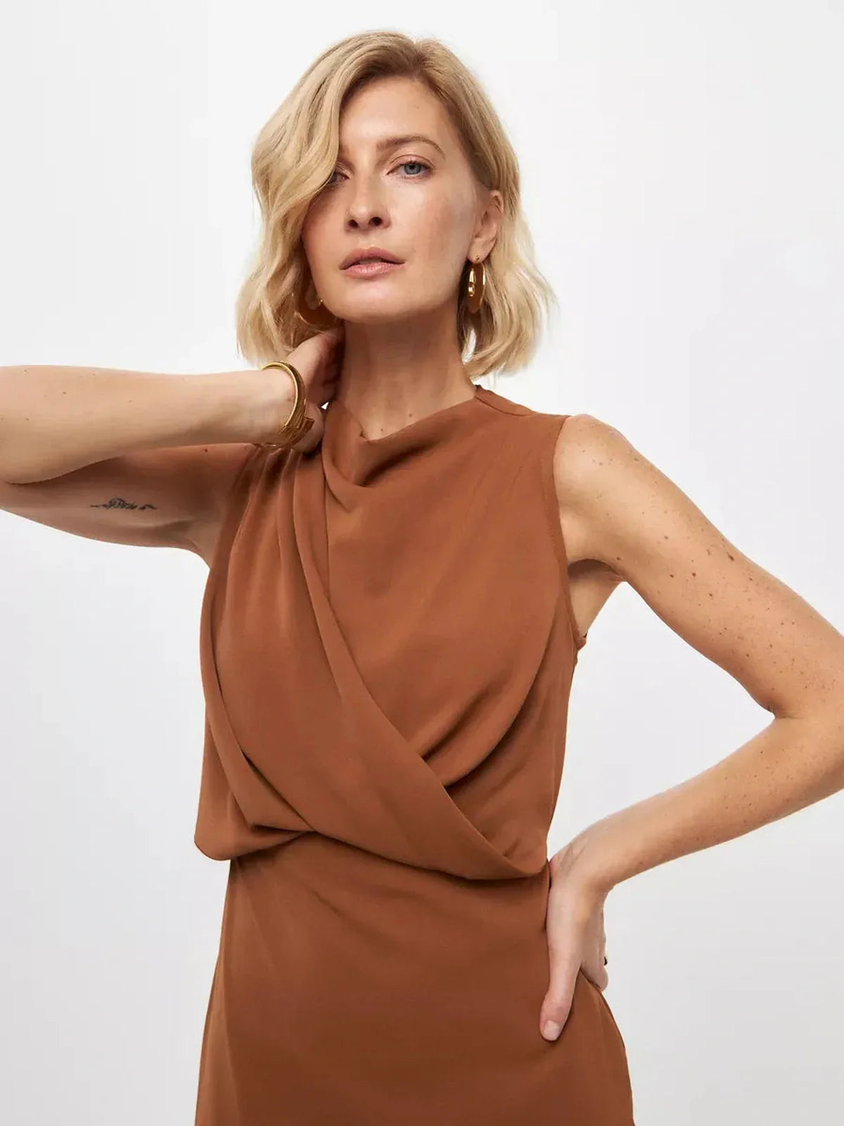 Model showcasing Sculpted Drape Maxi Dress in warm light brown, featuring elegant draping and a refined neckline.